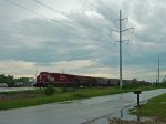 CP 8795 leads a detoured unit grain train across Highway 51 on the Madison branch